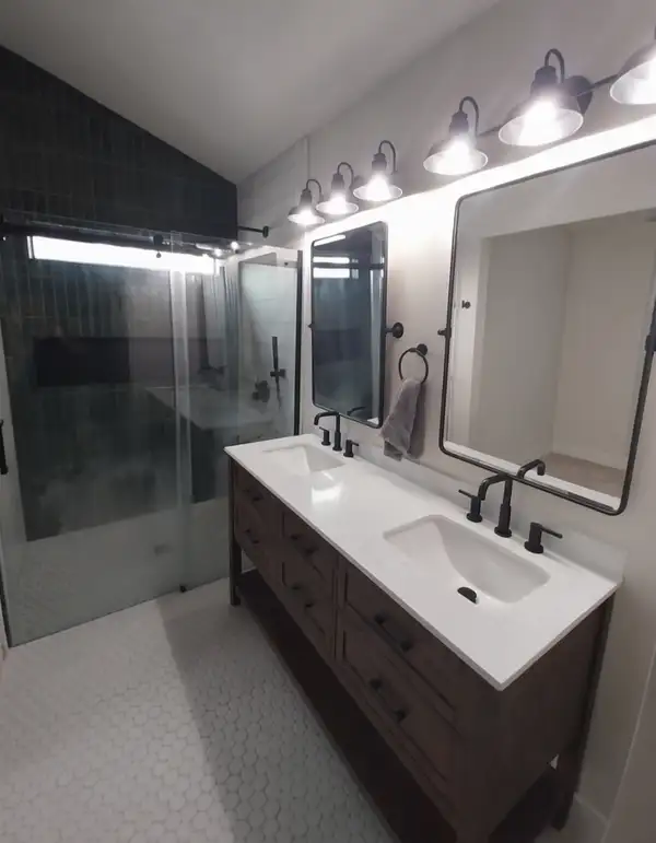 Remodeled bathroom with a double vanity and black faucets