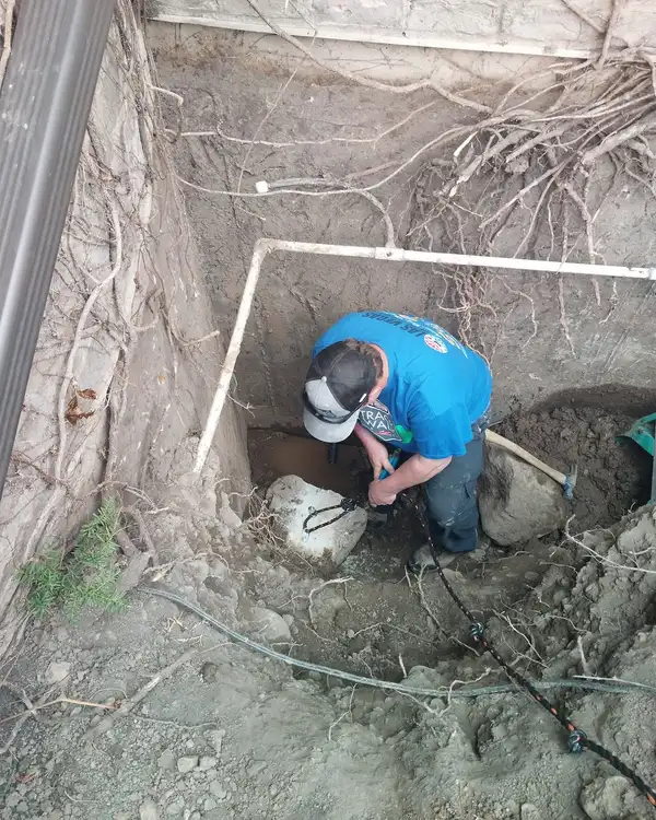 Plumber repairing a leaking underground water line