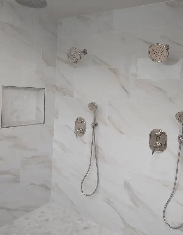 Marble walk-in shower with a rain head and two hand showers