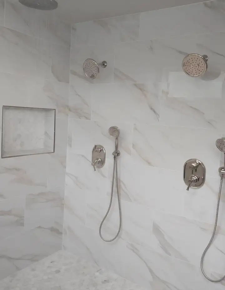 Marble walk-in shower with a rain head and two hand showers