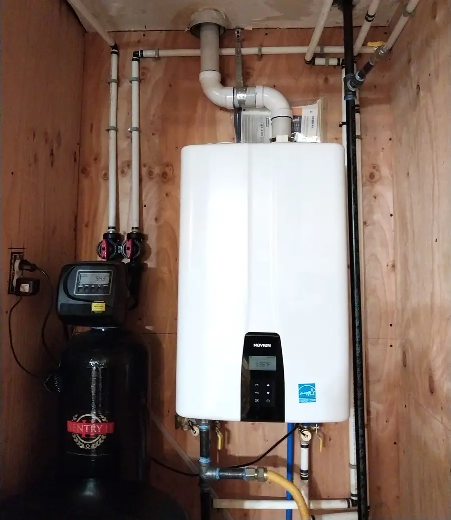 Wall-mounted tankless water heater installed next to a water softener