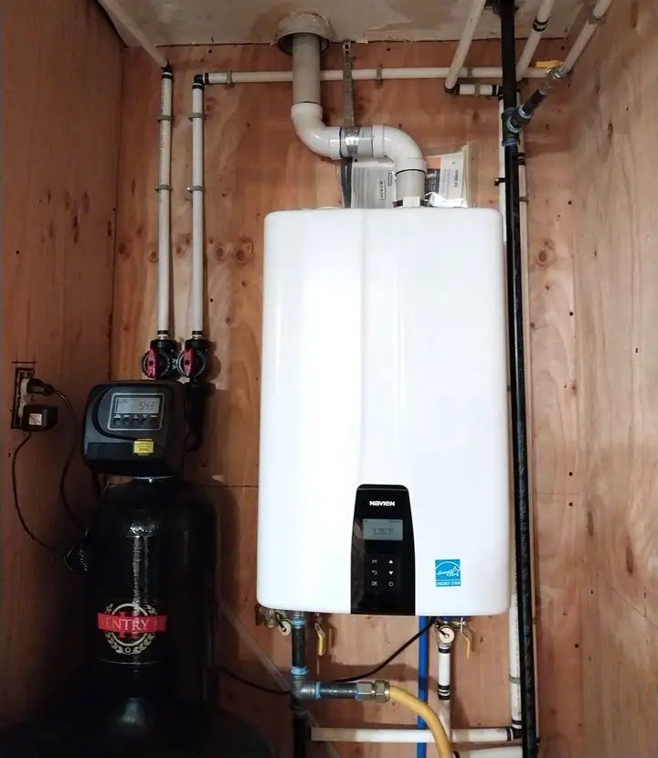 Tankless water heater mounted on a wall next to a water softener