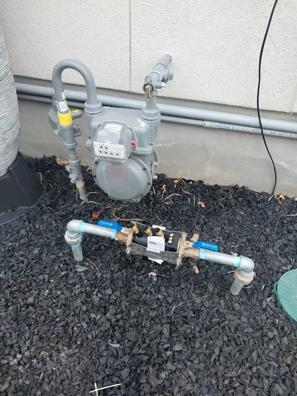 Backflow preventer installed next to a gas meter