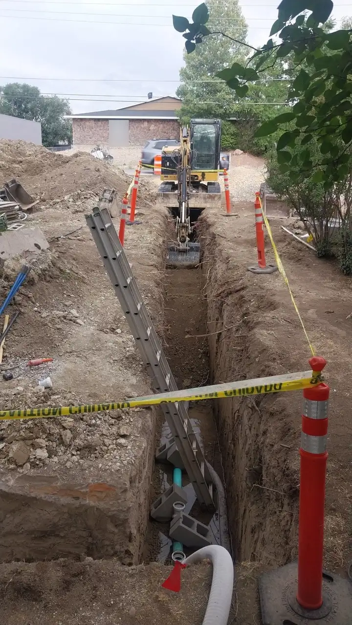 Sewer line trench with safety cones and caution tape